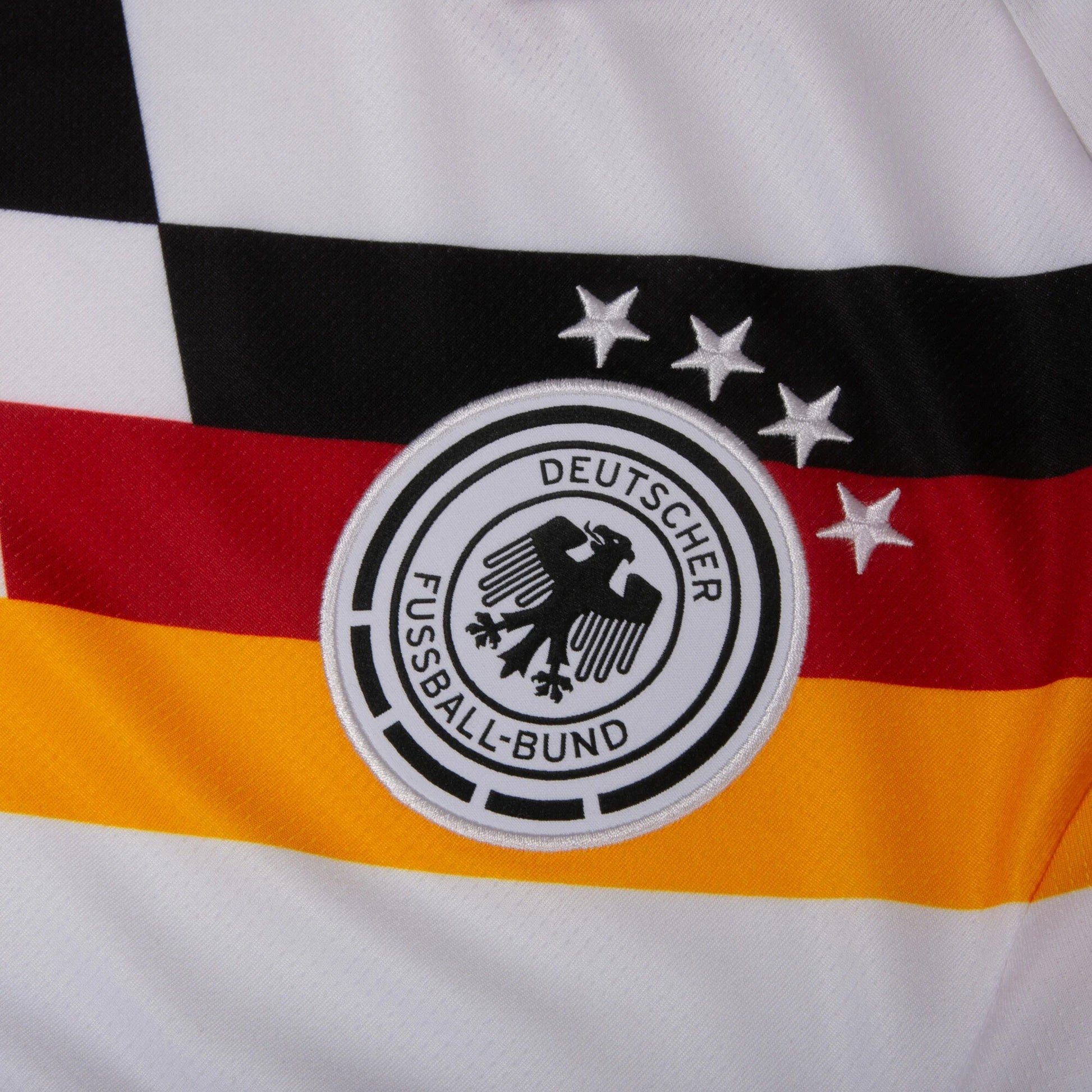 Close-up of a sports jersey with German national football team logo and colors.