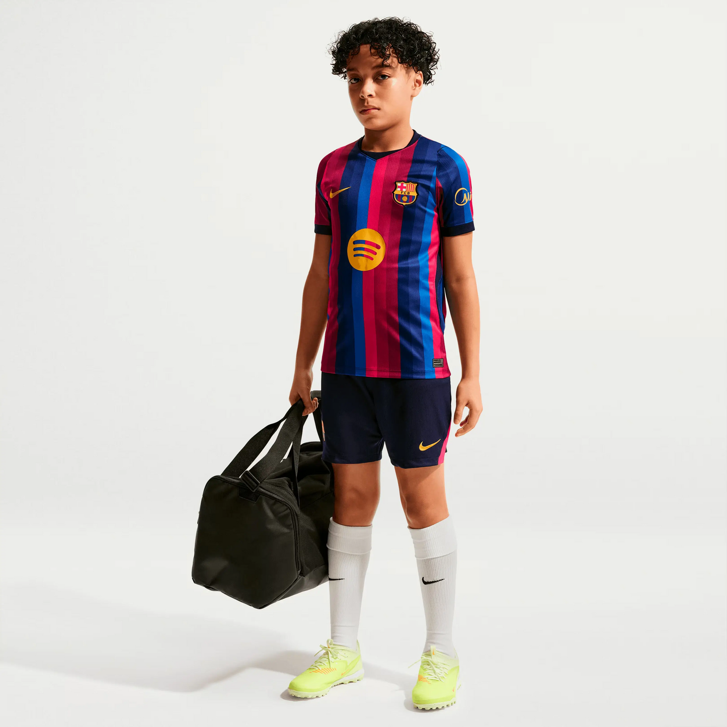 A Boy Wearing A 2627 Barcelona Home Jersey With A Bag