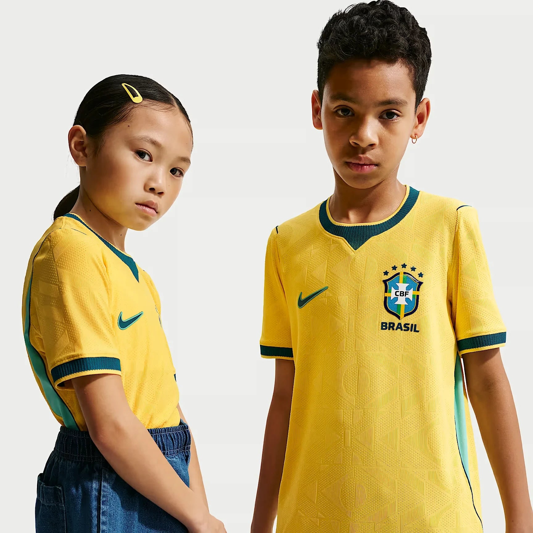 A Boy And Girl Wearing  Brazil 2026 World Cup Home Kids Stadium Replica Jersey