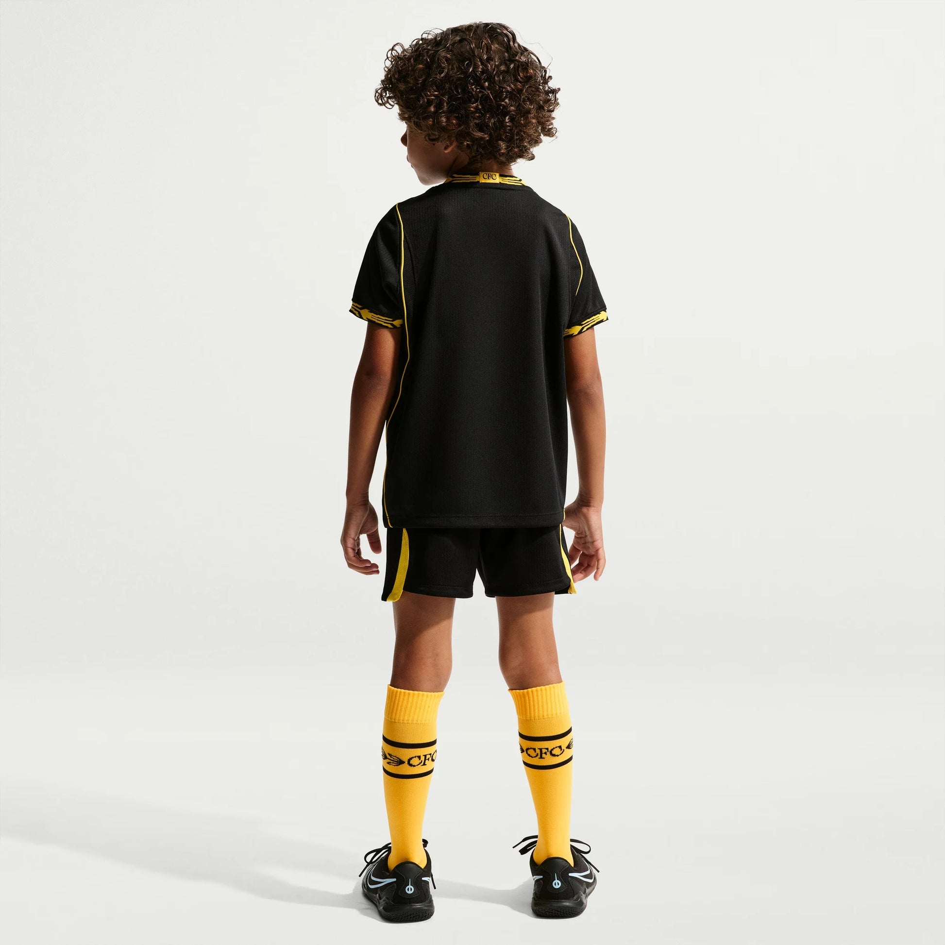 A child model shown from the back wearing a black Chelsea Preschool 2026/27 Away Stadium Replica Kit Set