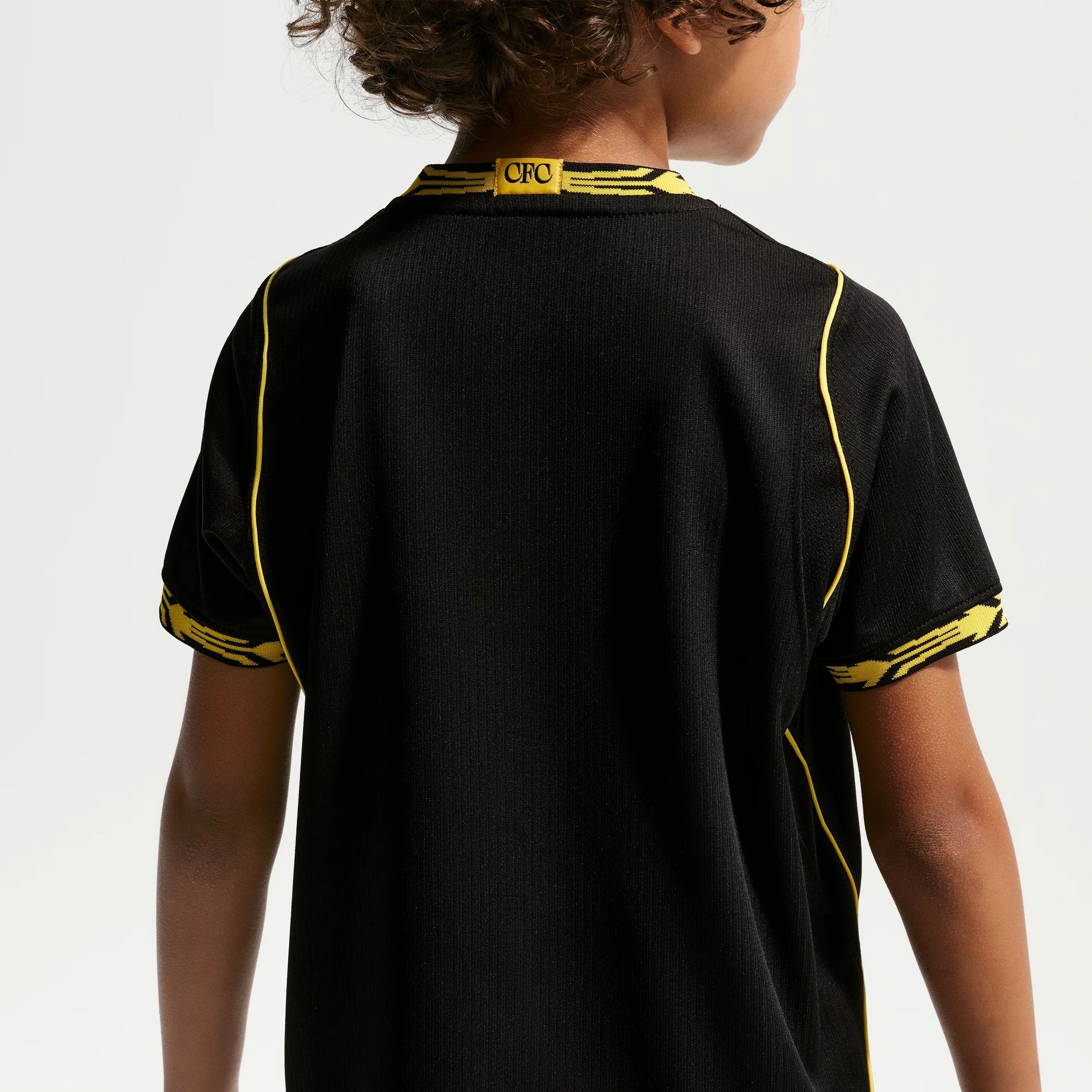 A child viewed from the back wearing a black Chelsea Preschool 2026/27 Away Stadium Replica Kit Set