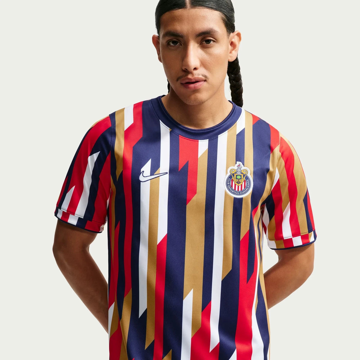 A man wearing a Chivas 2026-2027 home white Dri-FIT pre-match top