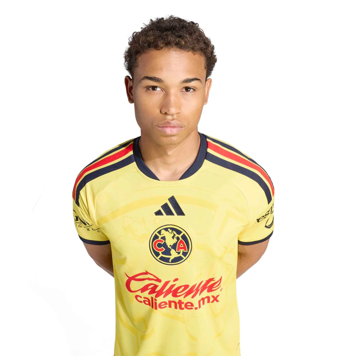 A young man wearing a yellow Club América soccer jersey with navy and red shoulder stripes, the Adidas logo, and the Club América crest, photographed against a plain white background.