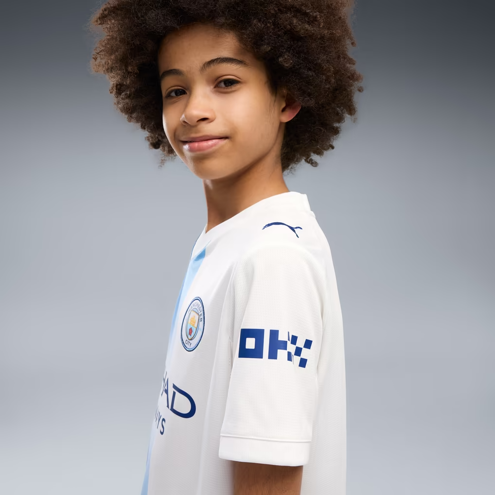 A Boy Wearing A Manchester City 26/27 White Third Jersey