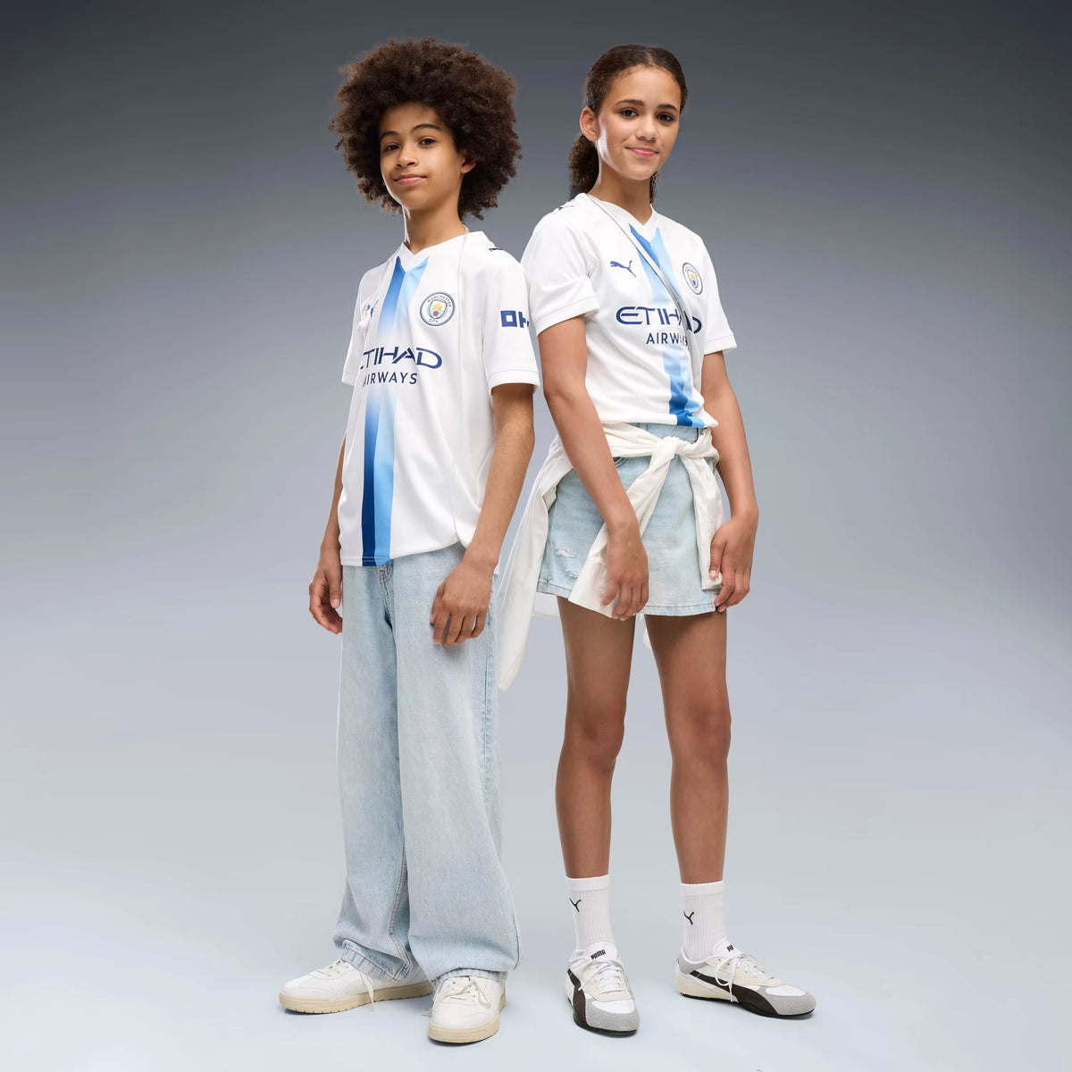 A Boy And A Girl Wearing A Manchester City 26/27 White Third Jersey