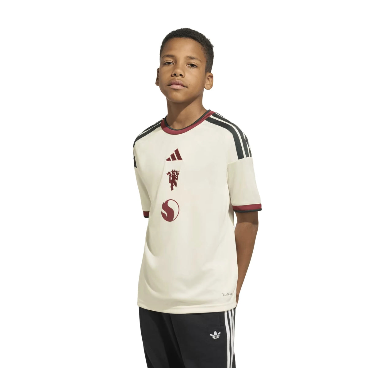 A boy wearing a Manchester United Youth 2026_27 Third Replica Jersey - Cream