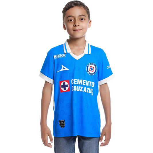 A young boy modeling a bright blue Cruz Azul soccer jersey with white trim, featuring sponsor logos like Cemento Cruz Azul and Nike, set against a plain white background.