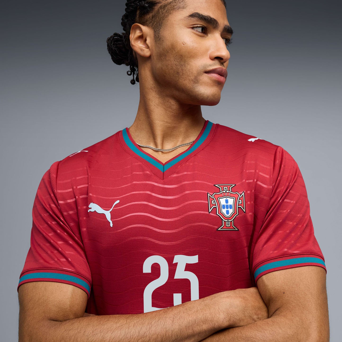 Person wearing a red sports jersey with a logo and number on a gray background