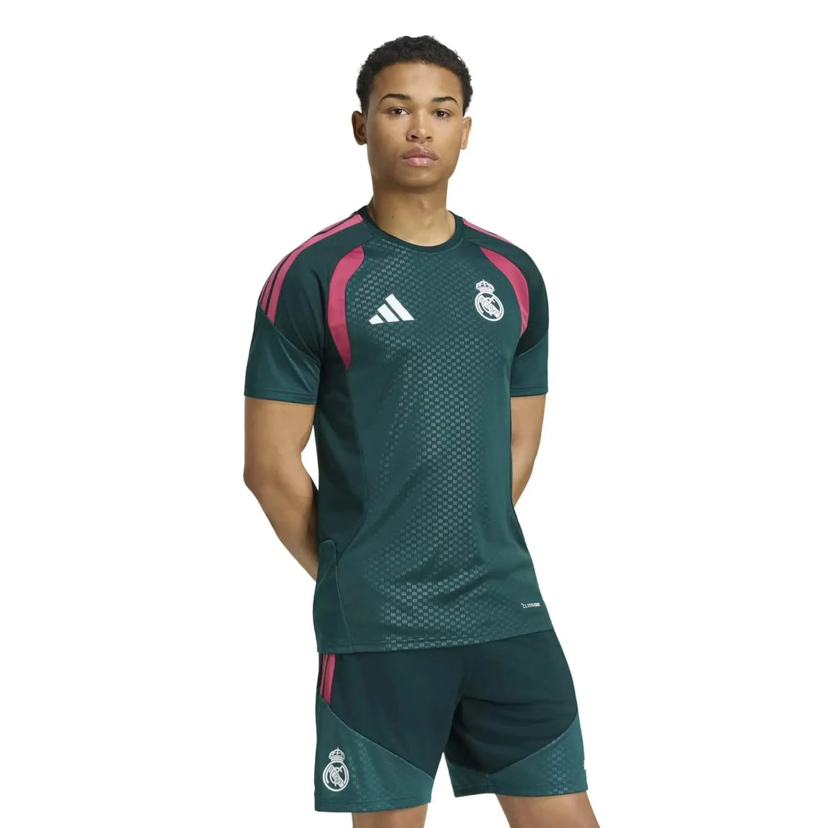 Person wearing a green sports outfit with Adidas and Real Madrid logos on a white background