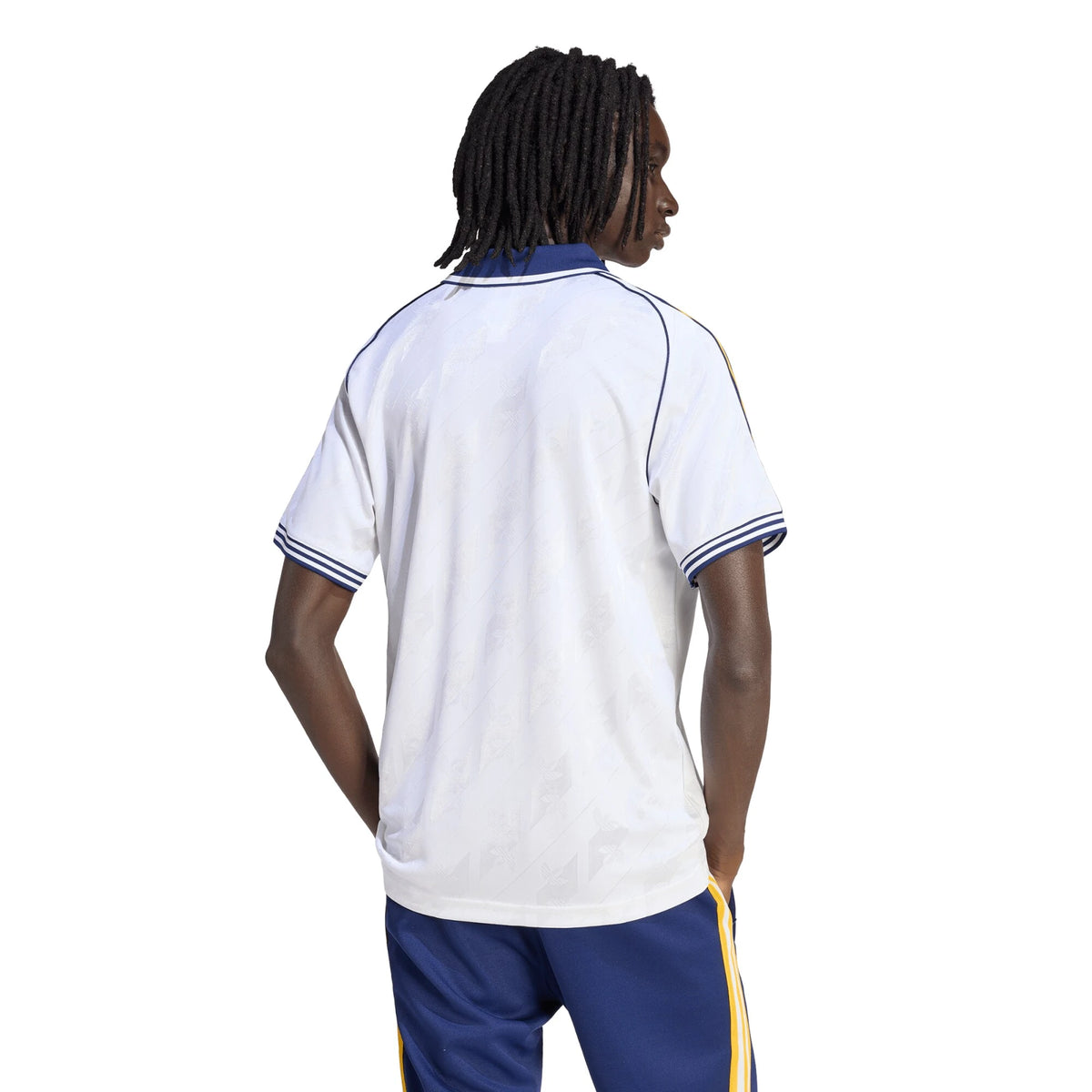 Person wearing a white sports jersey with blue shorts on a white background
