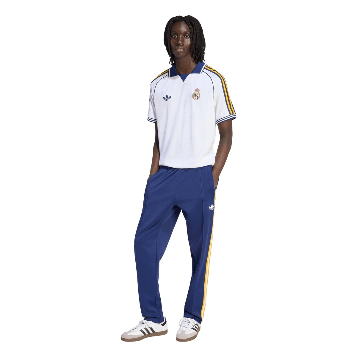 Person wearing a white and blue tracksuit with Adidas logo on a white background