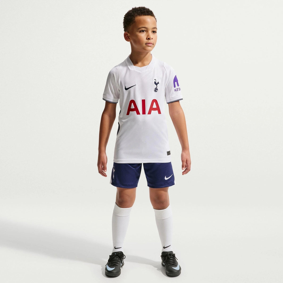 Child wearing a Tottenham Hotspur sports kit on a white background