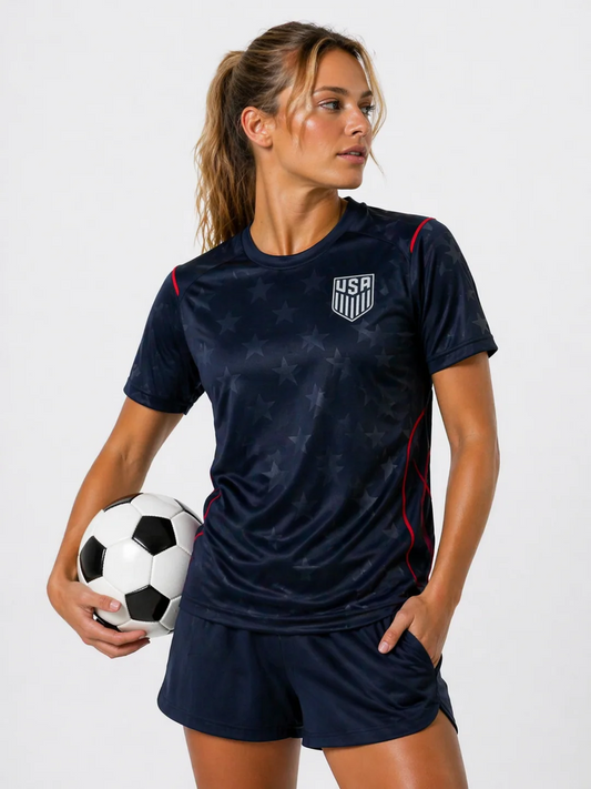 Woman wearing a navy sports outfit with USA logo, holding a soccer ball on a white background